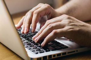 パソコンで下調べしている男性